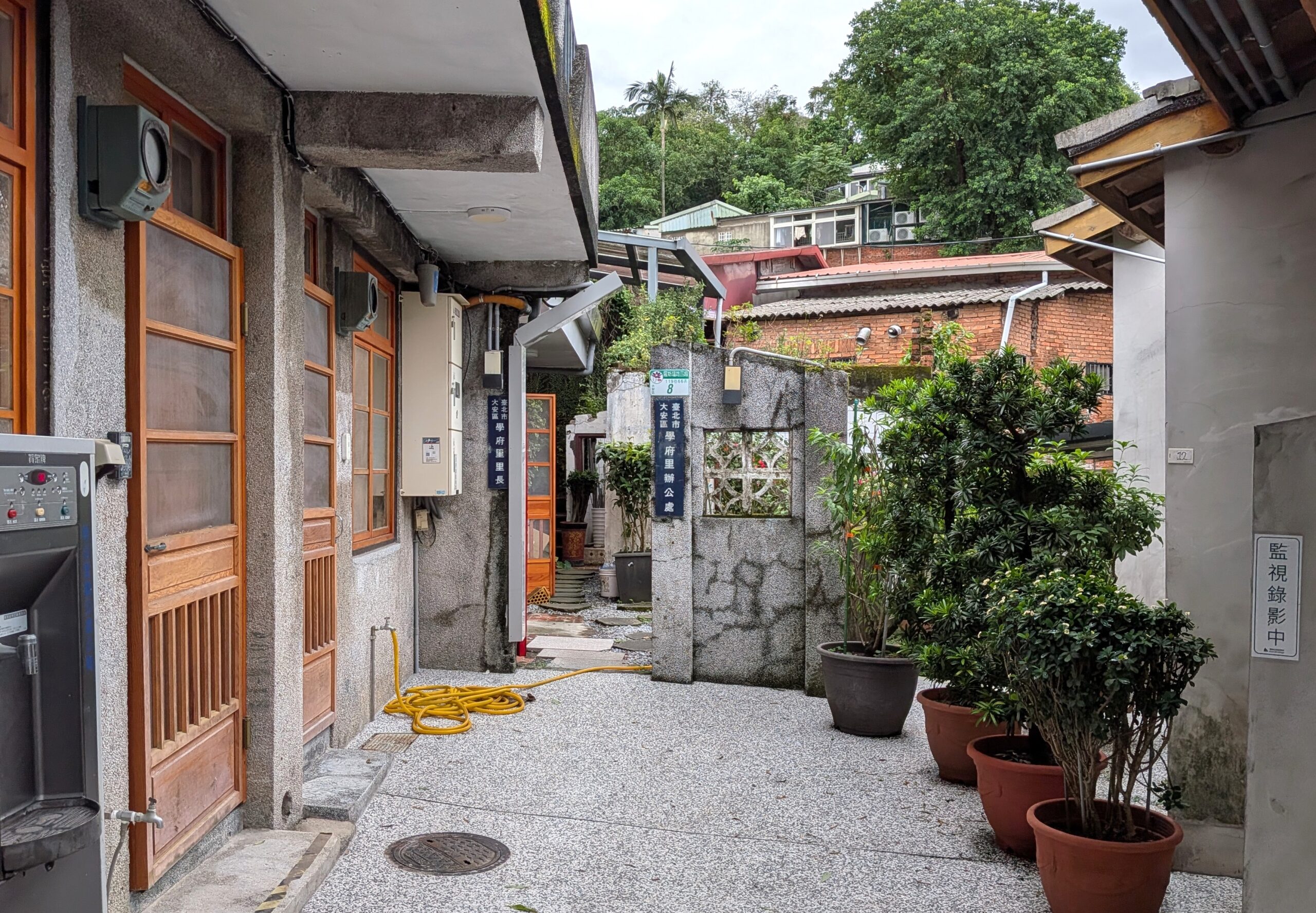 煥民新村の古い住宅の間に残る狭い路地と、昔の面影を伝える木製建具やコンクリートの壁。