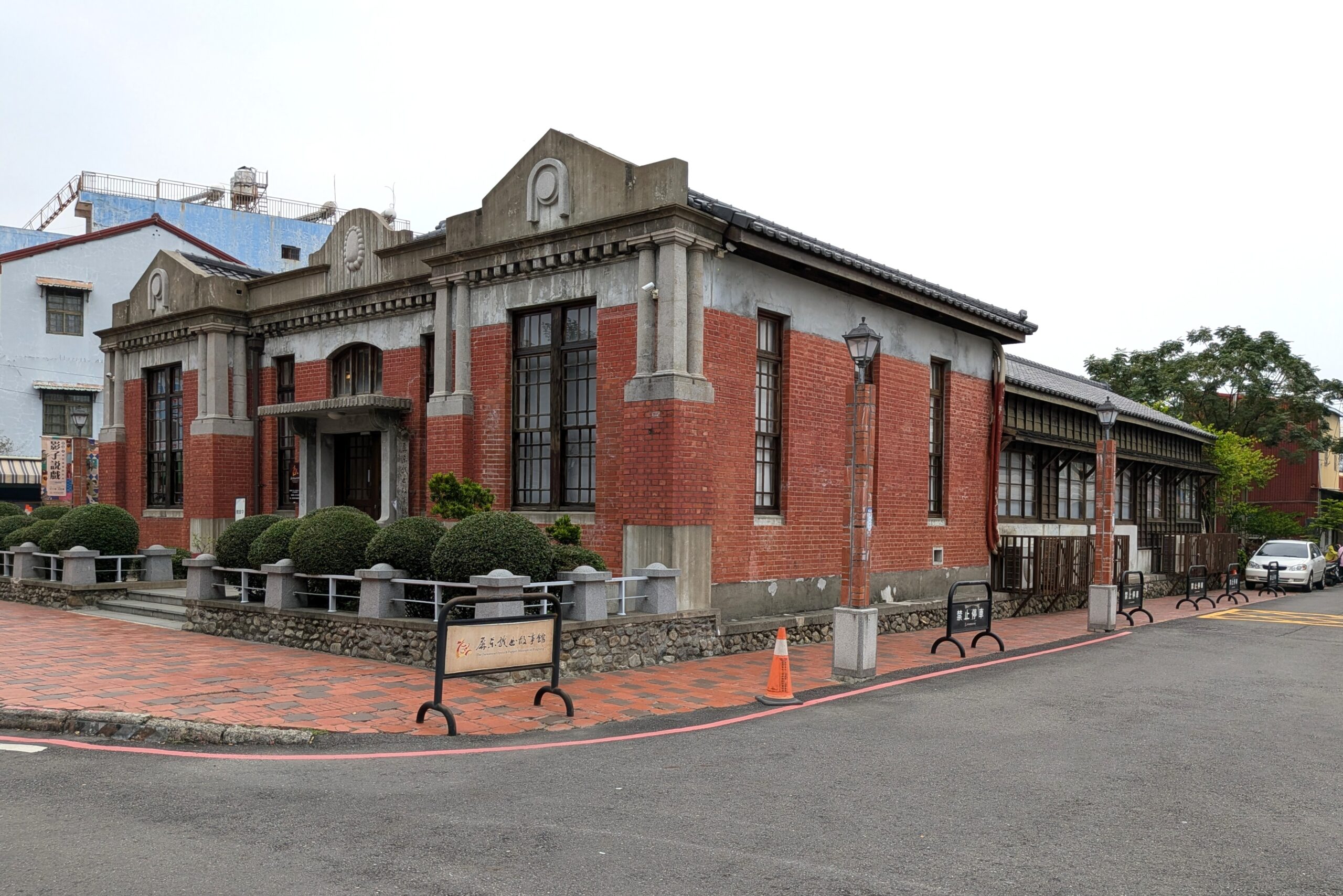 屏東戯曲故事館の正面に建つ洋風建築と、その奥に続く木造建築を組み合わせた外観。