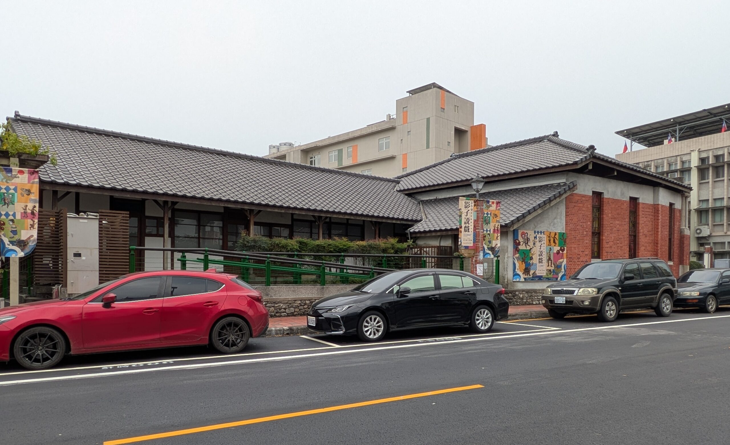 屏東戯曲故事館の裏側から見た、瓦屋根が広がる規模の大きな木造建築の外観。