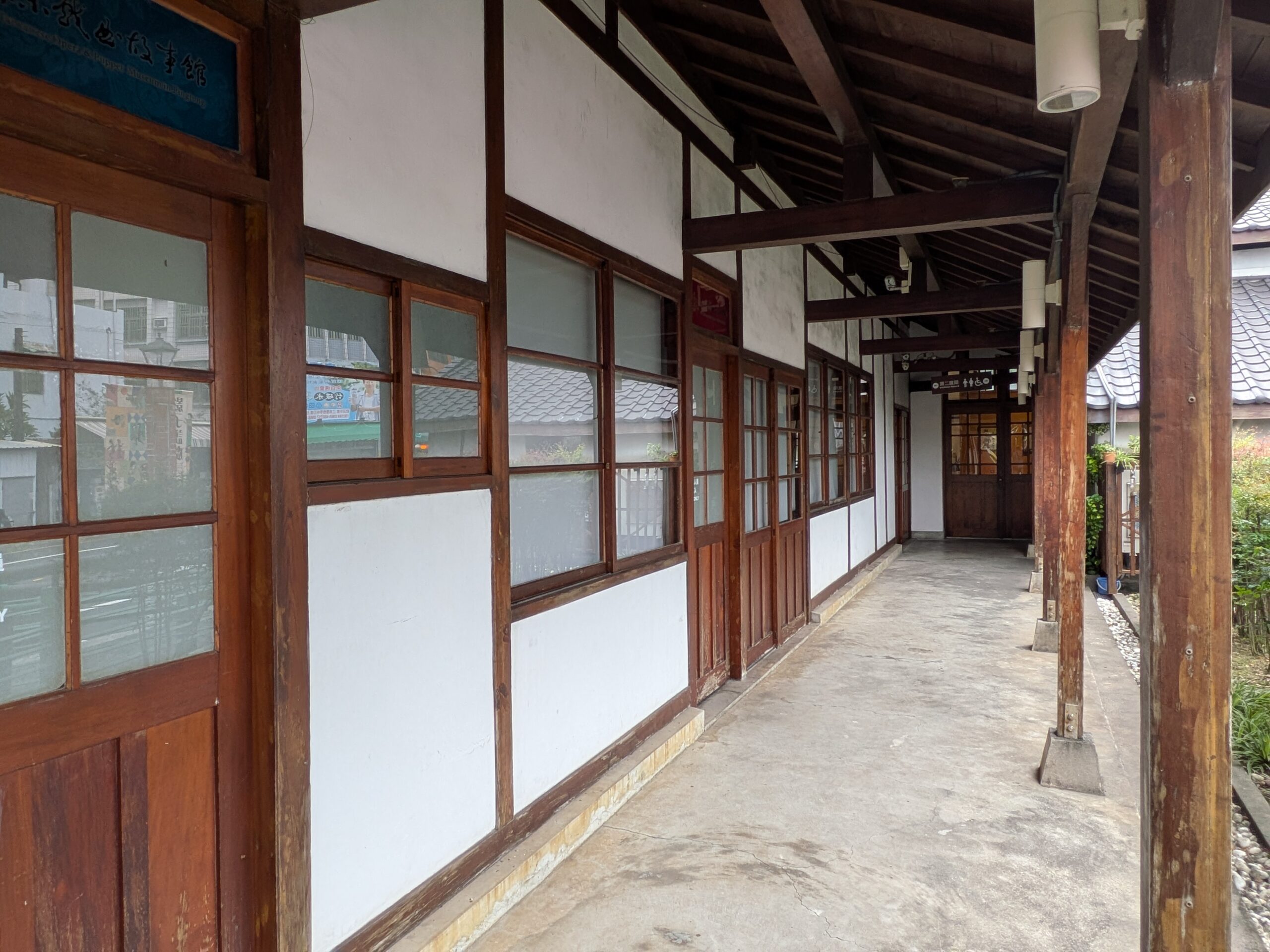 深い軒の下に木製建具が連続する、屏東戯曲故事館の開放的な木造建築の廊下。