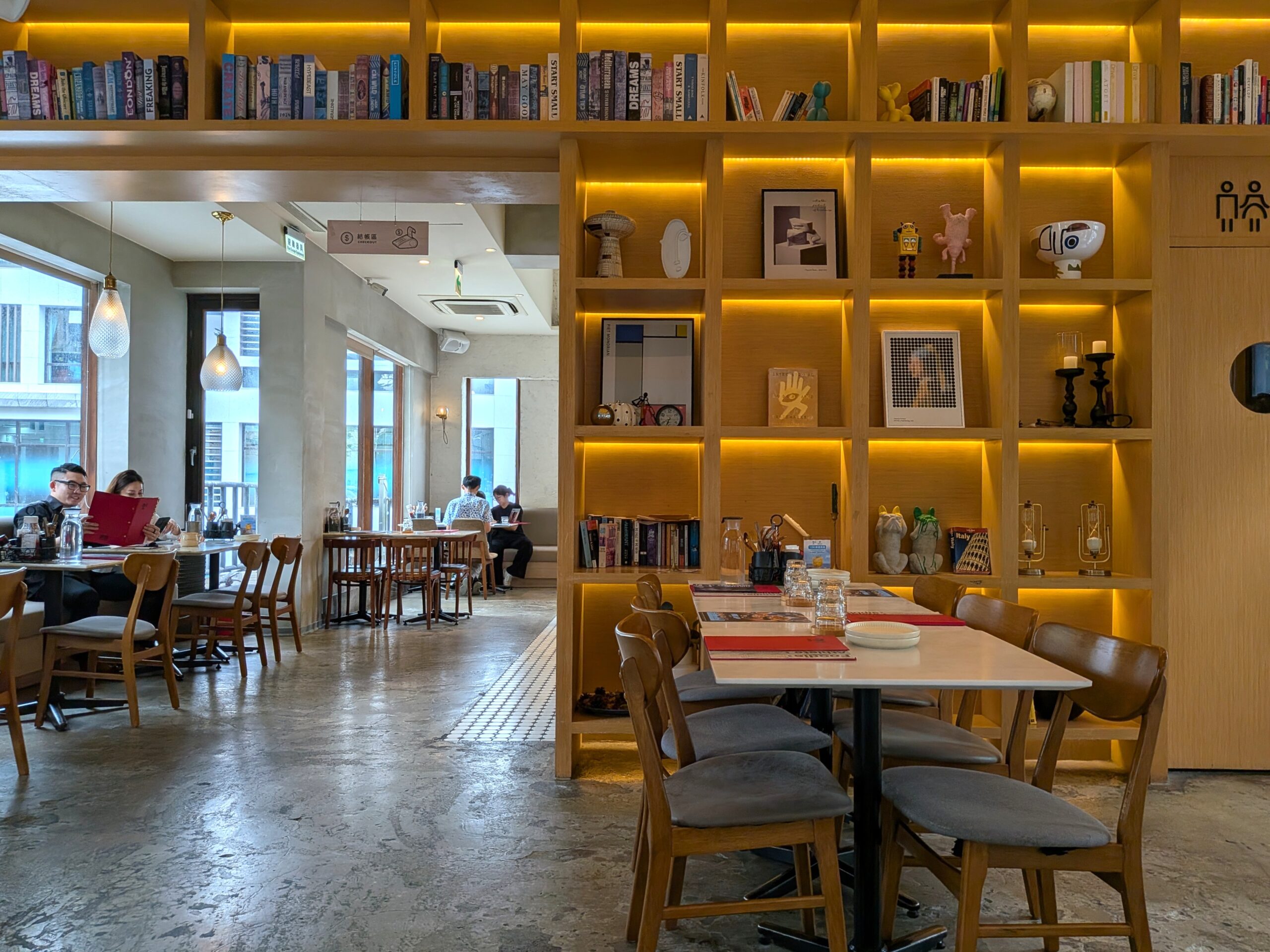 本棚の間仕切りと客席 貳樓公館店の本棚を兼ねた間仕切りで区切られた客席と、自然光が差し込む大きな窓。