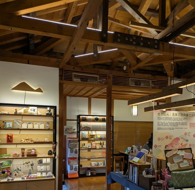 グッズショップ 旅人書店の室内にあるグッズや雑貨を扱うショップエリア。木製什器に陳列されている。
