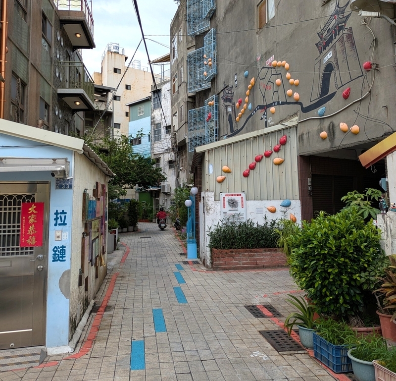 小西街の通りの路面が水色に塗られ、来街者への道案内を兼ねている様子。建物の外壁にはアートが描かれている。