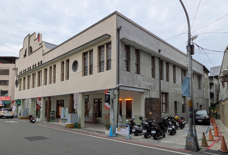 船の甲板を模した屋根や丸い舷窓などの特徴をもつ建物の外観を撮影した写真。