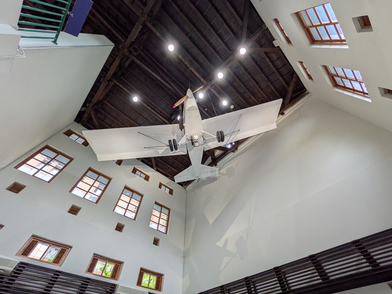 博物館内部に展示された台湾大学設計の軽飛行機。白い壁と木造小屋組が調和する展示空間。