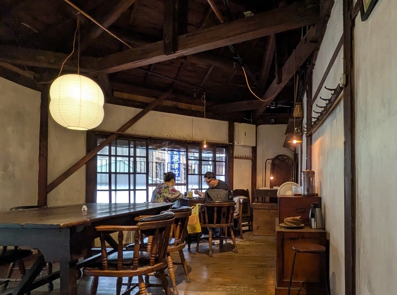小屋組の天井 テーブル席の上部に見える日本建築的な小屋組の天井構造。