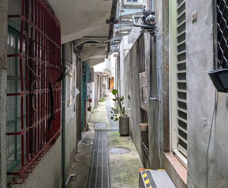 増築建物と路地 住民による増築で形成された建物と細い路地。建物は現在ワークスペースとして使われている。