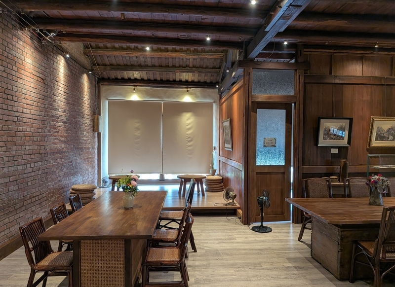 古い建物の内部を生かしてテーブルと椅子を配置した2階のカフェ客席。