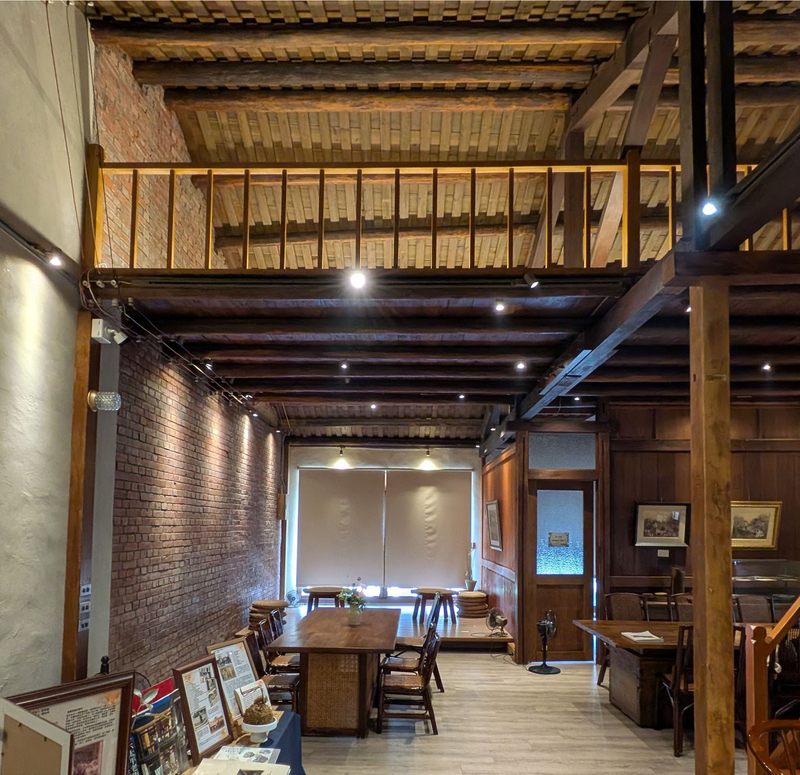 吹き抜けとロフトを組み合わせた開放的な内部。手前には建物の歴史を紹介する資料が置かれている。