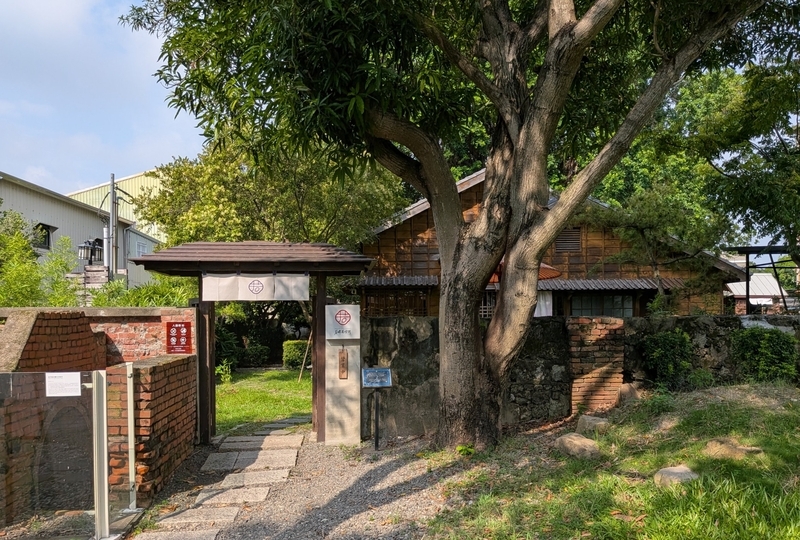 門扉から木々に囲まれた建物へと続くアプローチ。