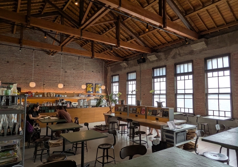 HAUSINC CAFEの店内 高い天井と小屋組、縦長の窓が特徴的な2階のHAUSINC CAFEの店内。